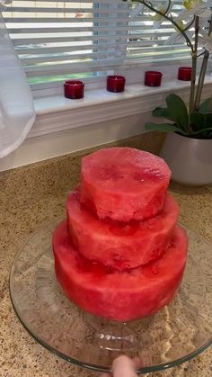 a watermelon cake sitting on top of a glass plate