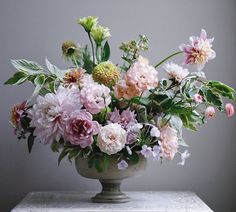 a vase filled with lots of flowers on top of a table