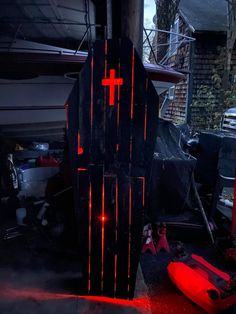 a large wooden cross is lit up in the dark with red light coming from it