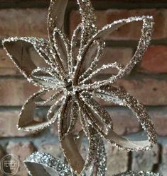 a silver metal flower on top of a brick wall