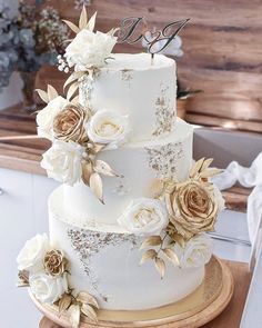 a wedding cake with white and gold flowers