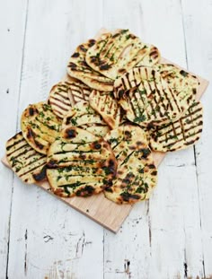 small pizzas are arranged on a cutting board and ready to be served for consumption