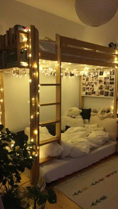 a loft bed with lights strung from the ceiling and mattresses on the bottom bunk