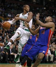 the basketball players are trying to block the ball from being fouled by another player