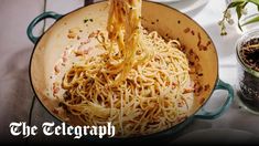 a pot filled with noodles and sauce on top of a table