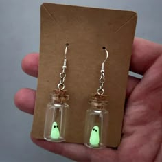 Spook up your style with these glow-in-the-dark ghost bottle earrings! Perfect for adding a touch of Halloween fun to any outfit. These quirky earrings are sure to turn heads and make a statement. (Don't worry, they won't haunt you at night.) Are you ready to make a spooky statement with your style? These ghost bottle earrings will add a touch of Halloween fun to any outfit, guaranteed to turn heads and keep the fun alive all night long. (Don't worry, no hauntings involved!) Ghost In Bottle, Dark Ghost, Fish Hook Necklace, Bottle Earrings, Dolphin Earrings, Ghost Earrings, Tanah Liat, Viking Bracelet, Style Gothic