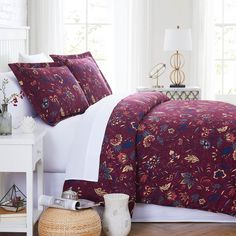 a bed with red and white comforters in a room