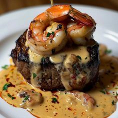 a steak with shrimp and sauce on it