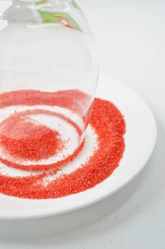 a bowl filled with red sand on top of a white plate