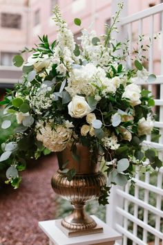 a vase filled with white flowers sitting on top of a table