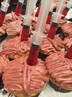 some pink frosted cupcakes with tubes sticking out of them