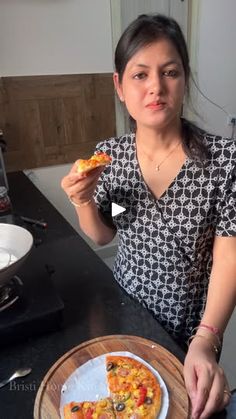 a woman sitting at a table with a plate of food in front of her and one piece of pizza on the plate