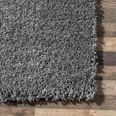 a gray rug on top of a wooden floor