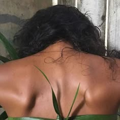 the back of a woman's head wearing a green strapless top with leaves on it