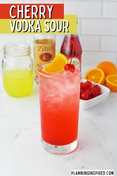 a red drink with oranges and raspberries in the background