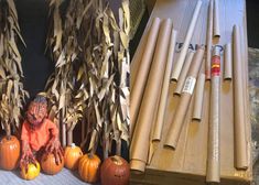 some pumpkins and other items are sitting on the floor next to each other in front of an assortment of sticks