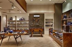 the inside of a store with many items on shelves and wooden tables in front of them