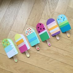 five popsicle shaped magnets sitting on top of a wooden floor