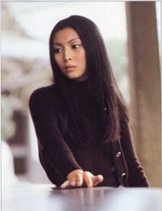 a woman sitting at a table with her arms crossed