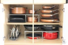 pots and pans are sitting on shelves in the cupboard