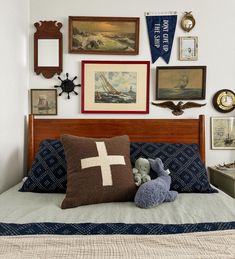 a bed topped with pillows and pictures on the wall