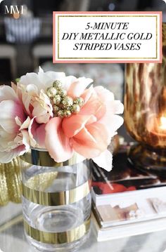 a vase filled with flowers sitting on top of a glass table next to a candle