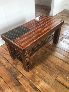 a wooden table with an american flag painted on it's top, sitting on a hard wood floor