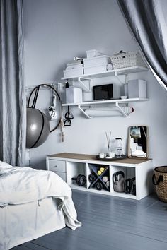 a bedroom with white walls and shelves filled with items