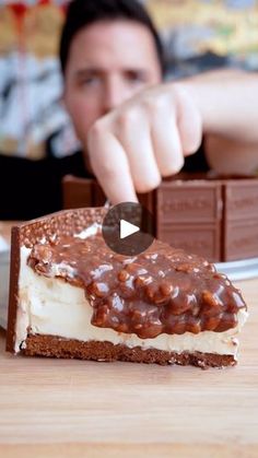 a man is eating a piece of cake with chocolate and nuts on the top, as if he was about to eat it