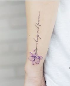 a woman's arm with a purple flower on it and the word love written in cursive writing