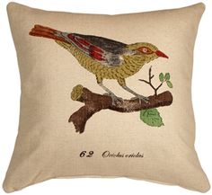 a bird sitting on top of a branch next to a pillow that says,'22 gardens '