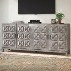 an entertainment center with a television mounted on the wall and a rug in front of it