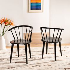 two black chairs sitting on top of a rug