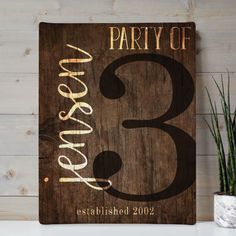 a wooden sign that says party of 3 and has the number three painted on it