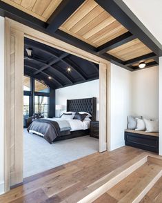 a large bedroom with wooden floors and white walls