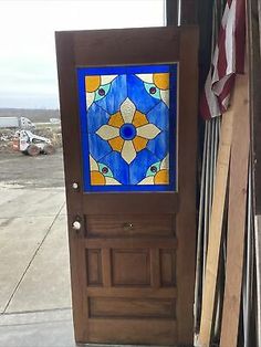 a wooden door with a stained glass design on the side and american flag in the background