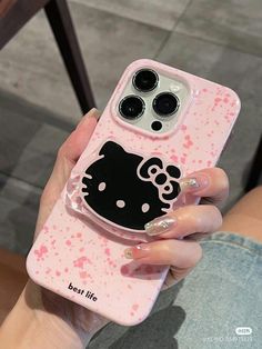 a person holding a pink phone case with hello kitty on it