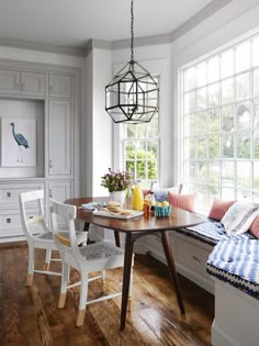 the dining room table is surrounded by white cabinets and chairs, along with a breakfast nook