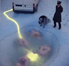 a man standing in the snow next to a white van with donuts on it