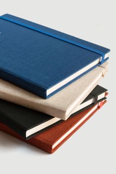 three books stacked on top of each other, one is blue and the other is brown