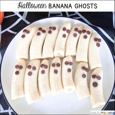 a white plate topped with sliced bananas and chocolate dots on it's side, along with the words halloween banana ghosts