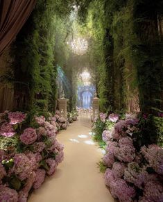 a garden with lots of pink flowers and greenery on the walls, surrounded by lush green foliage