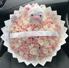 a bouquet of roses in the shape of a pig with a ribbon around its neck