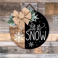 a sign that says let it snow on the side of a wooden wall with a bow