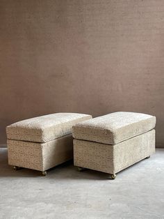 a pair of footstools sitting on top of each other in front of a wall