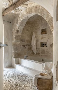 a bath room with a tub and a towel hanging on the wall next to it