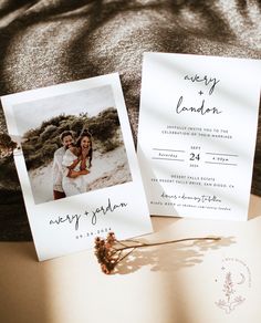 two wedding cards with the same photo on them are laying next to each other and one is holding a dried flower