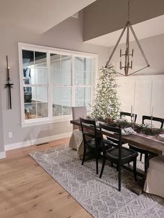 a dining room with a christmas tree in the center and other decorations on the table