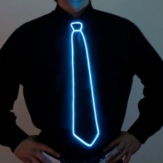 a man in a black shirt and tie has his hands on his hips while wearing a glowing light up necktie