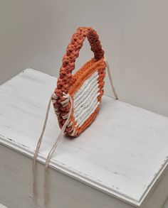 an orange and white basket sitting on top of a book